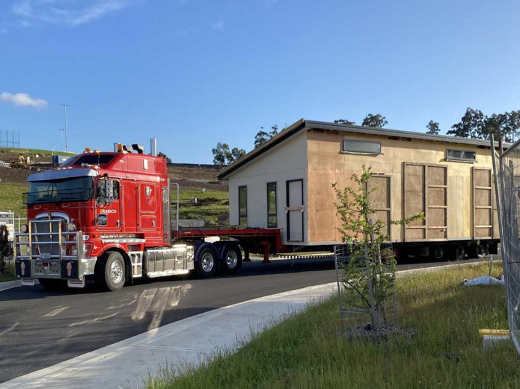 The living wing arrives, protected from the elements by wooden blanks