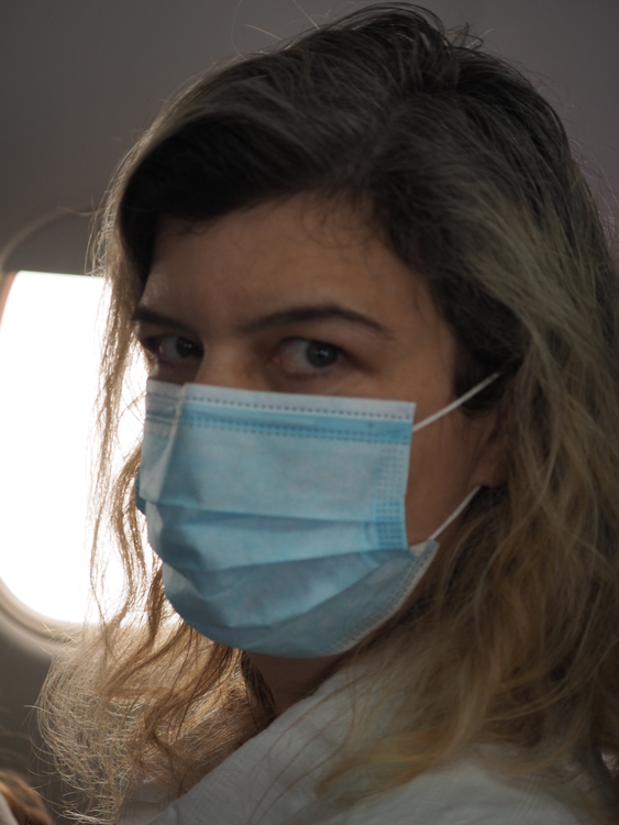Bronwyn in her COVID-19 face-mask aboard the plane.