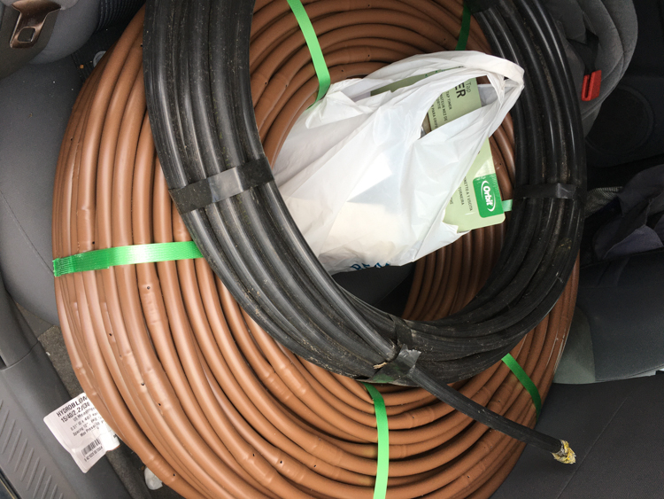 Constant feed drip line (brown), irrigation piping (black) and a bag full of parts