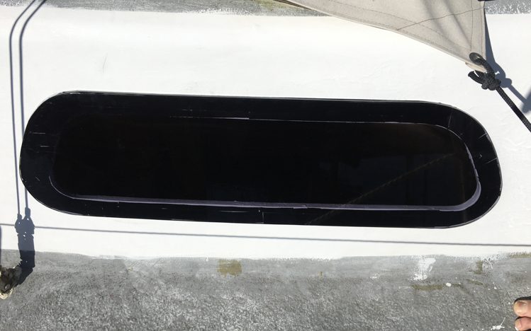 Acrylic window fitted to the boat, with white paint showing through the joints in the VHB tape