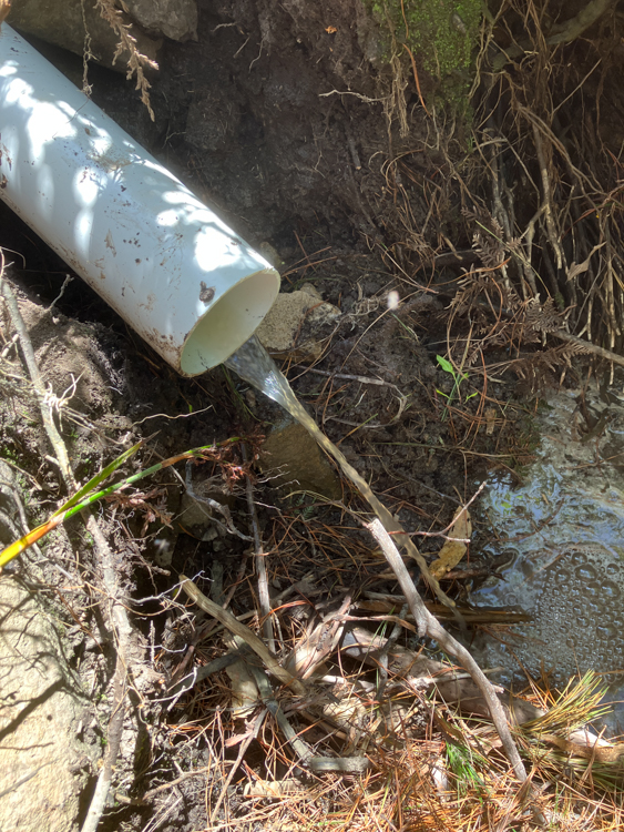 The creek diverts through the drainage pipes